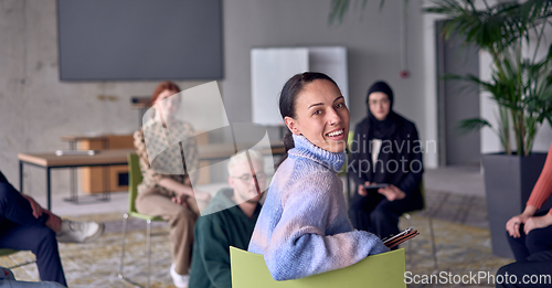 Image of A young female entrepreneur is attentively listening to a presentation by her colleagues, reflecting the spirit of creativity, collaboration, problem-solving, entrepreneurship, and empowerment.