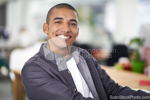 Image of Feeling filled with satisfaction. A smiling young designer in the office.