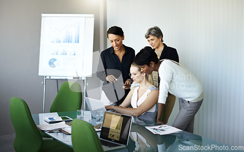 Image of Everyone take a look at this. a group of coworkers having a meeting in the boardroom.