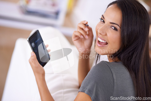 Image of I made the upgrade to touchscreen. Portrait of an attractive young woman using her stylus and touchscreen phone at home.