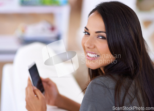 Image of This is a fantastic phone. Portrait of an attractive young woman using her mobile phone at home.