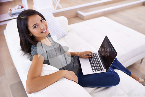 Image of My little helper at home. Portrait of an attractive young woman using her laptop at home.