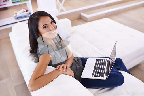 Image of Working from home today. Portrait of an attractive young woman using her laptop at home.