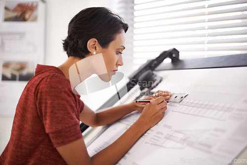 Image of Paying attention to the finer details. an attractive young architect working in her office.