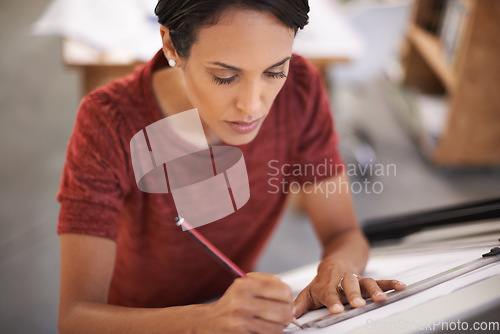 Image of Adding a few things. an attractive young architect working in her office.