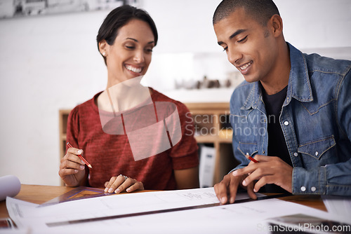 Image of Working late to meet the deadline. two young designers working together in an office.