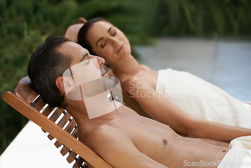 Image of Enjoying a lazy day with someone special. a mature couple relaxing side by side on lounge chairs outside.