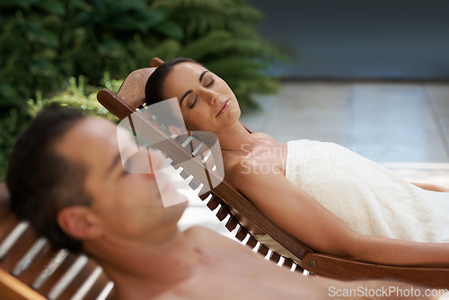 Image of Resolved to relaxation. a mature couple relaxing side by side on lounge chairs outside.