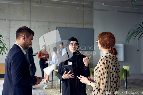 Image of A group of young business entrepreneurs engages in a lively discussion within the office, exemplifying the spirit of teamwork, innovation, and ambition in pursuit of success.