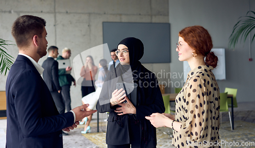 Image of A group of young business entrepreneurs engages in a lively discussion within the office, exemplifying the spirit of teamwork, innovation, and ambition in pursuit of success.