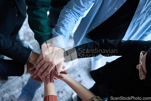 Image of A top view photo of group of businessmen holding hands together to symbolize unity and strength