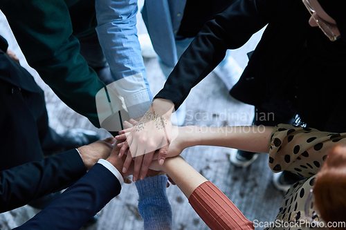 Image of A top view photo of group of businessmen holding hands together to symbolize unity and strength
