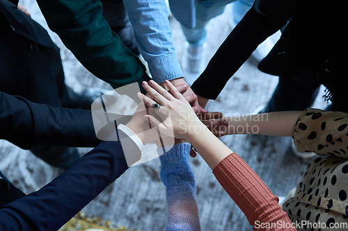 Image of A top view photo of group of businessmen holding hands together to symbolize unity and strength