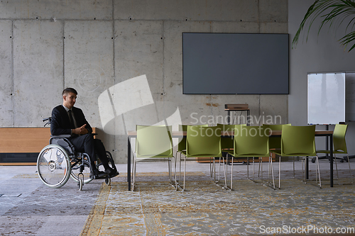 Image of Businessman in a wheelchair in a modern office lonely after a busy day