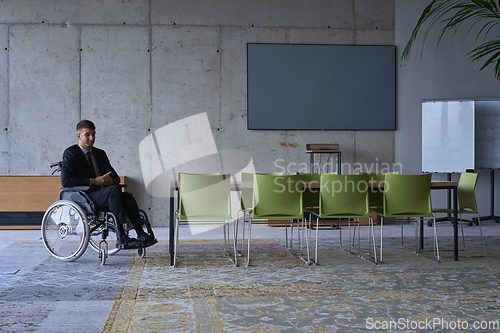 Image of Businessman in a wheelchair in a modern office lonely after a busy day