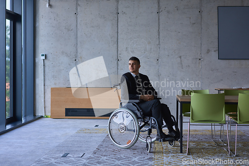 Image of Businessman in a wheelchair in a modern office lonely after a busy day