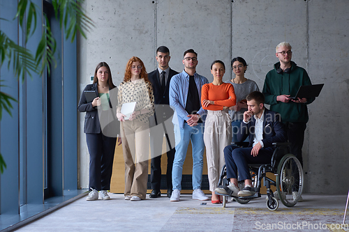 Image of Diverse group of business people, including a businessman in a wheelchair in a modern office