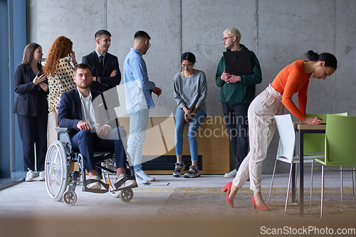 Image of Diverse group of business people, including a businessman in a wheelchair in a modern office