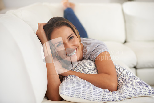 Image of Enjoying life as it happens one day at a time. Portrait of a woman enjoying herself on her living room sofa.