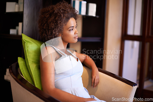 Image of Reflecting on the day. an attractive african american woman sitting in a chair.