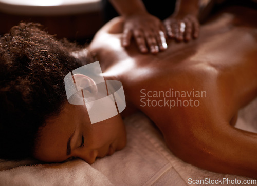 Image of Nothing but relaxation. a young woman enjoying a massage at a spa.