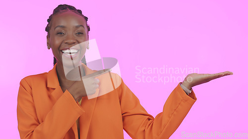 Image of Black woman, pointing and advertising in studio on empty hand, palm or mock up space. Portrait, happy or person with promotion for business, marketing or offer and presentation on pink background