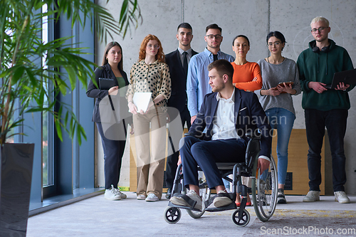 Image of Diverse group of business people, including a businessman in a wheelchair in a modern office