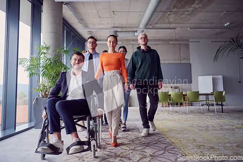 Image of A diverse group of businessmen, including a businessman in wheelchair, confidently stride together through a modern, spacious office, epitomizing collaboration, inclusivity, and strength in unity