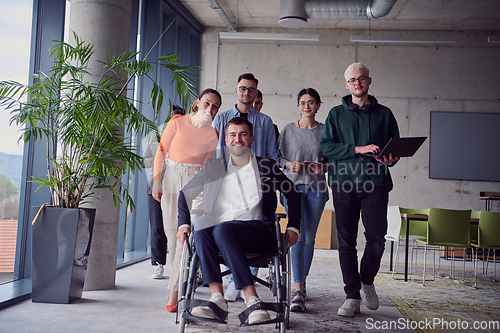 Image of A diverse group of businessmen, including a businessman in wheelchair, confidently stride together through a modern, spacious office, epitomizing collaboration, inclusivity, and strength in unity