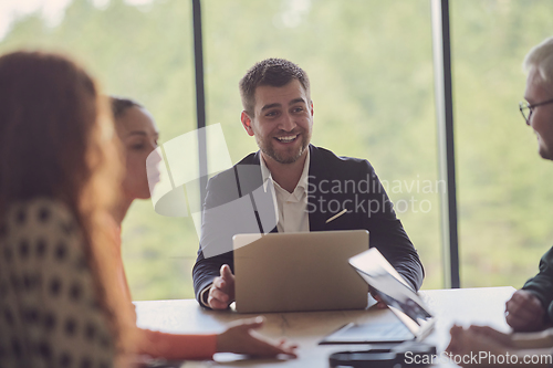 Image of A diverse group of business professionals gathered at a modern office for a productive and inclusive meeting