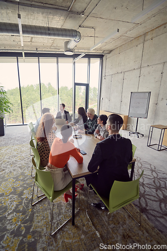 Image of A diverse group of business professionals gathered at a modern office for a productive and inclusive meeting