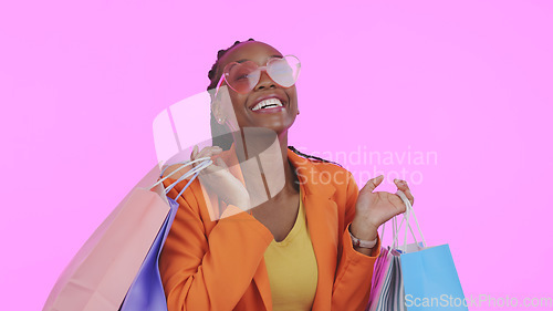 Image of Woman, shopping bag and sunglasses for fashion sale, discount and giveaway prize or competition in studio. Portrait of african person or excited customer with gift or funky style on pink background