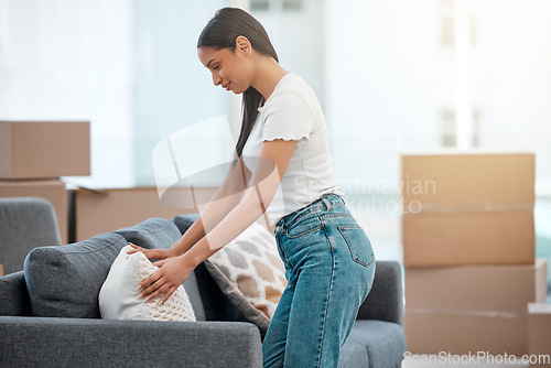 Image of You look right at home over here. an attractive young woman designing her sofa with pillows in her new home.
