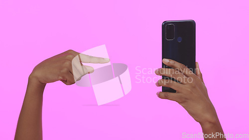 Image of Studio, hand holding phone and pointing for contact, connectivity or mobile networking. Social media, website and person with smartphone technology for communication, app or choice on pink background