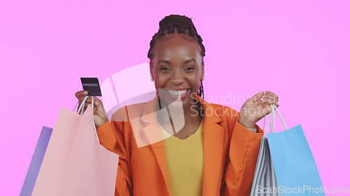 Image of Woman, portrait and credit card with shopping bag for financial success, sale and discount on pink background. Excited customer or african winner in celebration for banking, fashion or gift in studio