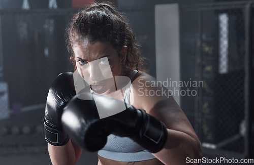 Image of You cant beat the best. Portrait of a young woman practicing her boxing routine at a gym.