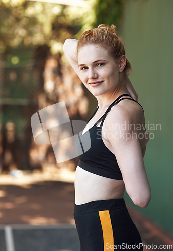 Image of Warming up my game. Cropped portrait of an attractive young female athlete stretching while standing on the basketball court.