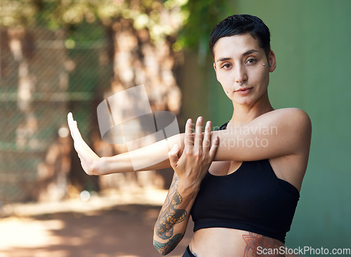 Image of You cant ball without warming up. Cropped portrait of an attractive young female athlete stretching while standing on the basketball court.