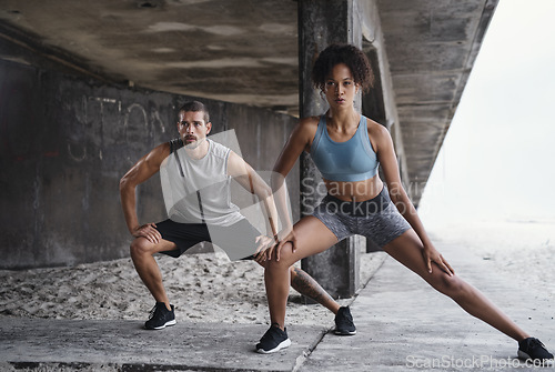 Image of Every stretch matters in the long run. Full length shot of a sporty young couple exercising together outdoors.