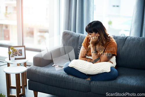 Image of Im still waiting on his call. a woman looking upset while staring at her cellphone.