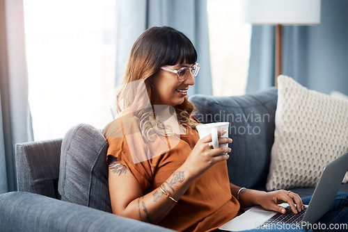 Image of Coffee and wifi is all I need today. a young woman using her laptop while relaxing at home.