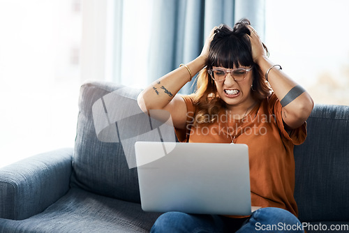 Image of Whats wrong with it. a woman looking frustrated while using her laptop at home.