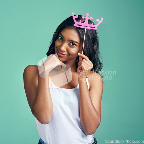 Image of Im a princess. Studio portrait of a beautiful young woman posing with a prop crown against a green background.