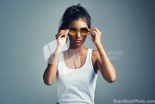 Image of Feeling cool. Studio portrait of a beautiful young woman posing against a grey background.