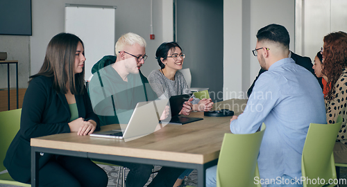 Image of A diverse group of business professionals gathered at a modern office for a productive and inclusive meeting