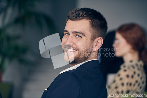 Image of A smiling entrepreneur sits in a modern office, actively participating in a business meeting, radiating confidence and professionalism.