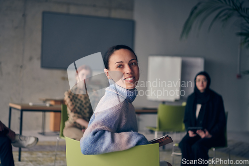 Image of A young female entrepreneur is attentively listening to a presentation by her colleagues, reflecting the spirit of creativity, collaboration, problem-solving, entrepreneurship, and empowerment.