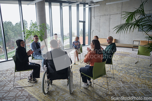 Image of In a modern office, a diverse group of business individuals is seen gathered in a circle, engaged in lively discussions and sharing ideas about various business concepts.