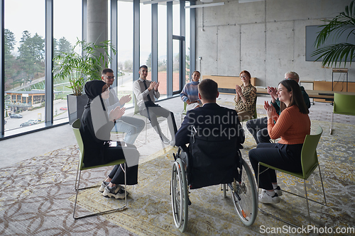 Image of In a modern office, a diverse group of business individuals is seen gathered in a circle, engaged in lively discussions and sharing ideas about various business concepts.