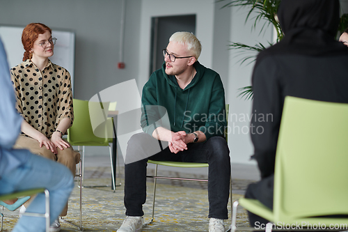 Image of A young businessman passionately sharing his business ideas with his colleagues, fostering an atmosphere of collaboration and innovation in a dynamic and engaging workplace